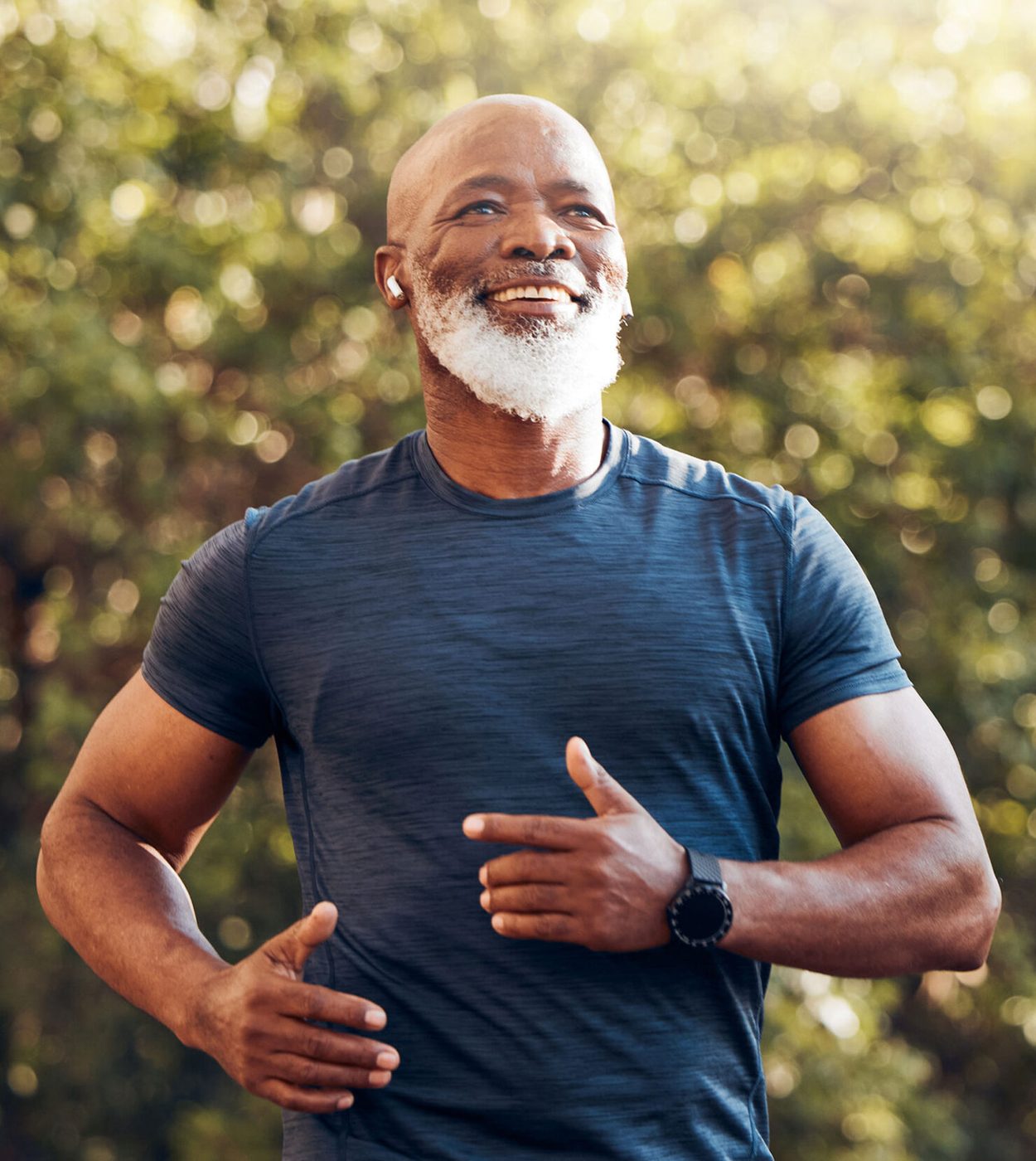 A man with a white beard jogging outdoors on a sunny morning